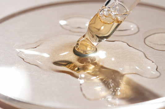 Gros plan d'une pipette et d'un gel ou sérum liquide jaune-orangé de rétinol ou de vitamine C sur fond beige